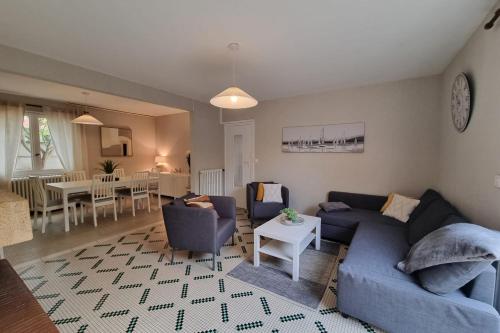 a living room with a blue couch and chairs at Large family house 300m from the beach in Arcachon