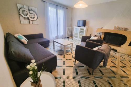 a living room with two couches and a fireplace at Large family house 300m from the beach in Arcachon