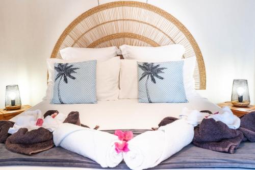 a bedroom with a bed with towels on it at Bungalow Kaz Orchidée Oncidium in Sainte-Anne