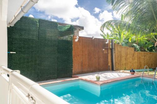 a swimming pool with a privacy fence and a swimming pool at Villa Kaz a Ramon in Port-Louis