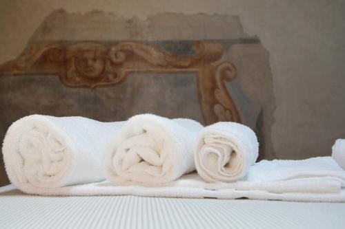 a pile of towels on top of a bed at Guest House Dell'Affresco in Reggio Emilia