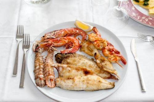 a plate of food with shrimp and chicken on a table at Regina Hotel e Ristorante in Punta Marina