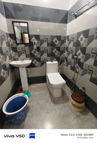 a bathroom with a toilet and a sink at Pushpanjli grand inn in Ayodhya