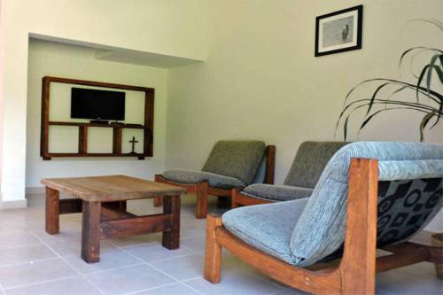 a living room with chairs and a table and a tv at Villas Huitepec in San Cristóbal de Las Casas