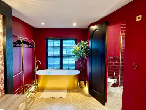 a bathroom with a tub and red walls at Hylton House in Birmingham