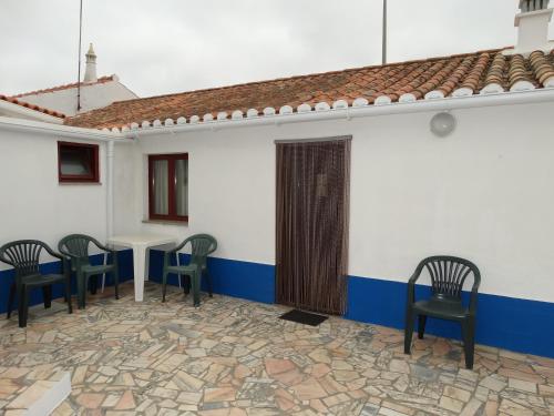 eine Terrasse mit Stühlen und einem Tisch in einem Gebäude in der Unterkunft Casa Campo e Praia in Rogil