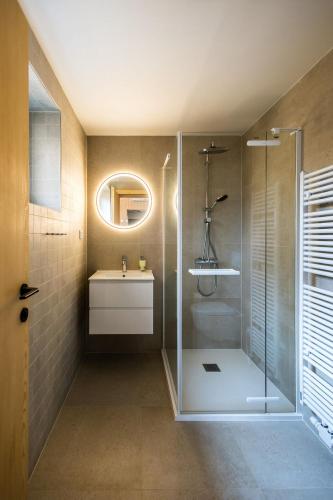 a bathroom with a shower and a sink and a mirror at Zastávka Vlkov in Vlkov