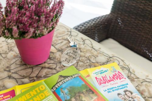 a table with books and a vase with a plant at Regina Hotel e Ristorante in Punta Marina