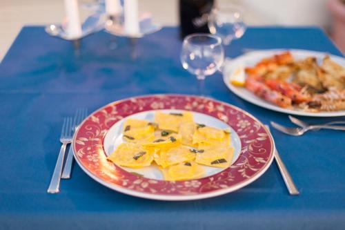 a table with two plates of food on a blue table at Regina Hotel e Ristorante in Punta Marina