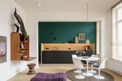 a kitchen with a table and a green wall at Great to stay Gent I rooms & apartments in Ghent