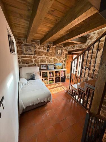 a bedroom with a bed in a room with a staircase at El Salto del Agua in Orbaneja del Castillo
