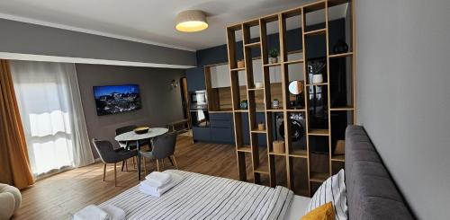 a room with a bed and a table and a kitchen at By The Pool Apartments #10 in Velingrad