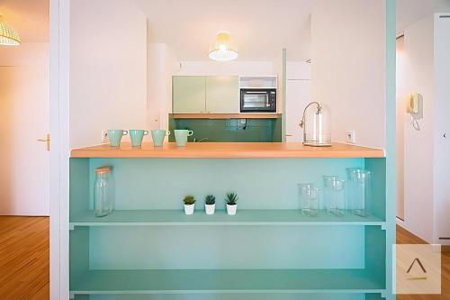 una cucina con una mensola blu con tre piante di Le Prieuré a Dinard