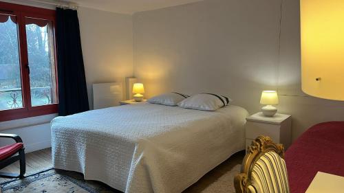 a bedroom with a bed with two pillows and a window at La Forge de Paul et Virginie in Mainneville
