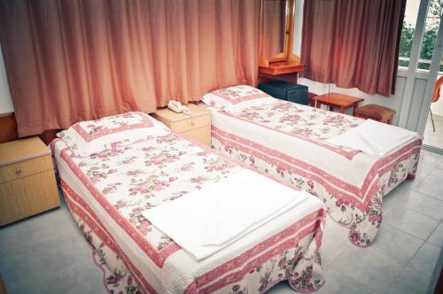 A bed or beds in a room at Kleopatra Beach Yildiz Hotel