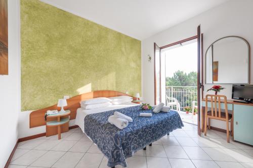 プンタ・マリーナにあるRegina Hotel e Ristoranteのベッドとバルコニー付きのホテルルーム