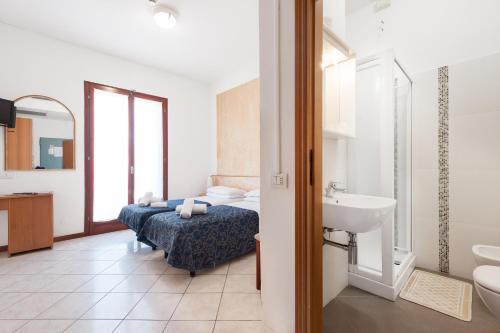 a bathroom with a bed and a sink in a room at Regina Hotel e Ristorante in Punta Marina