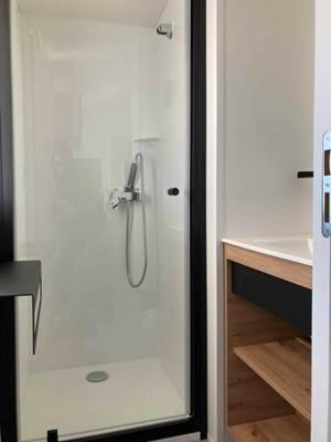 a shower with a glass door in a bathroom at Camping Vauban in Bergues