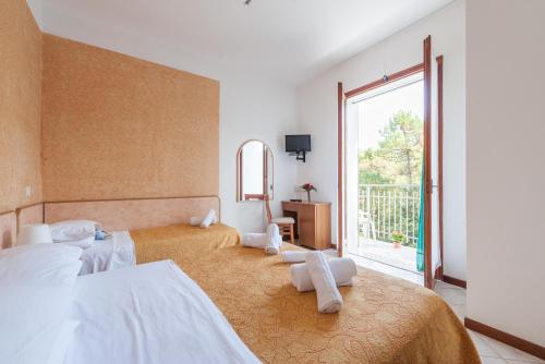 a bedroom with two beds and a large window at Regina Hotel e Ristorante in Punta Marina