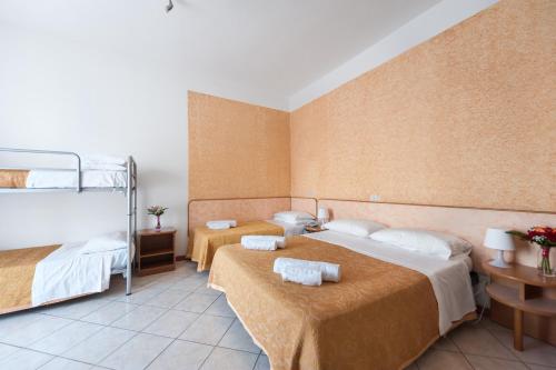 a bedroom with two beds and a bunk bed at Regina Hotel e Ristorante in Punta Marina