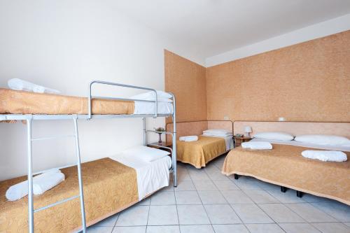 a room with three bunk beds in it at Regina Hotel e Ristorante in Punta Marina