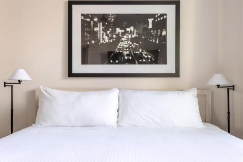 a bedroom with a white bed with two lamps at Kasa Love Field-Medical District Dallas in Dallas