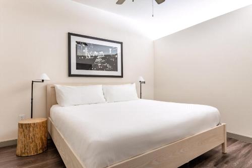 a bedroom with a white bed and a picture on the wall at Kasa Love Field-Medical District Dallas in Dallas