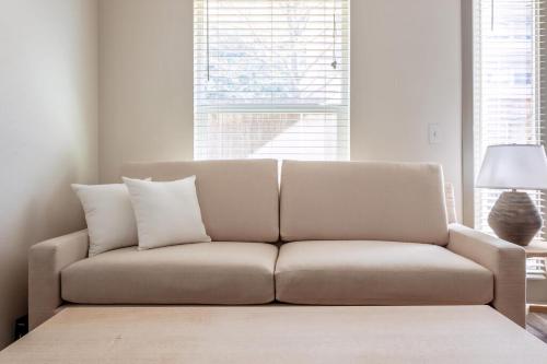 a couch in a living room with two pillows on it at Kasa Love Field-Medical District Dallas in Dallas