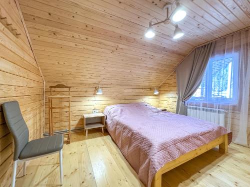 a bedroom with a bed in a wooden room at KaVacottage in Krivorovnya