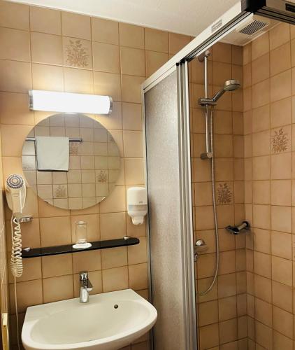ein Badezimmer mit Waschbecken und Dusche in der Unterkunft Hotel Jungbräu in Abensberg