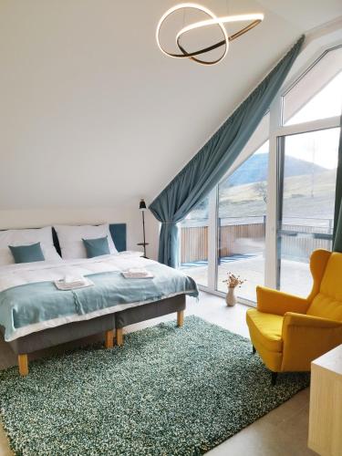 a bedroom with a bed and a couch and a chair at Chalupa pod Cárinkou in Zboj