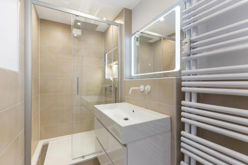 a white bathroom with a sink and a mirror at Ferienwohnung Bernhard in Wermelskirchen