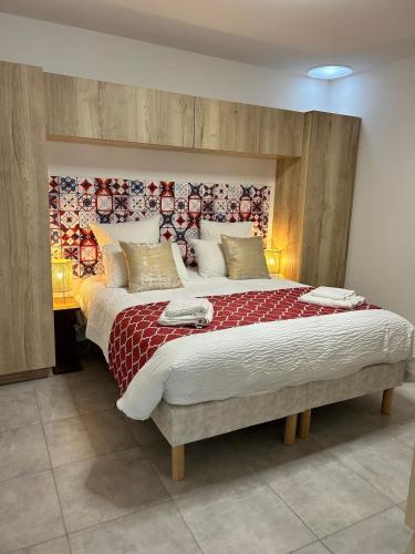 a bedroom with a large bed with a red blanket at La Belle Prise in Matougues