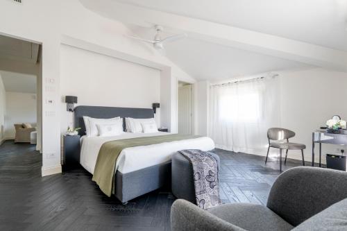 a bedroom with a large bed and two chairs at One Belvedere Tuscany in Poggibonsi