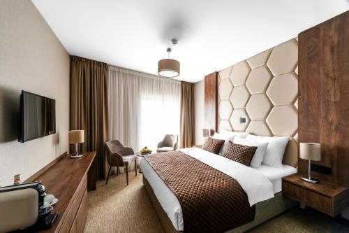ein Hotelzimmer mit Bett und Fernseher in der Unterkunft Amsterdam Hotel Pool & SPA in Belgrad