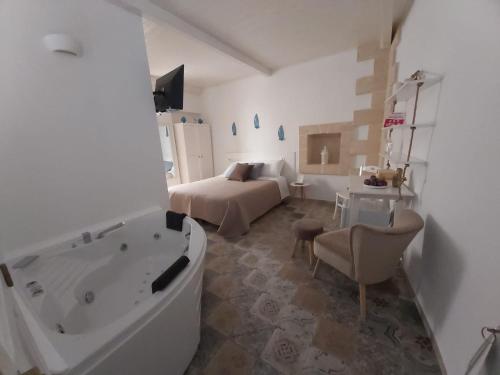 a bathroom with a bed and a tub in a room at Terracielo Guest House in Monopoli