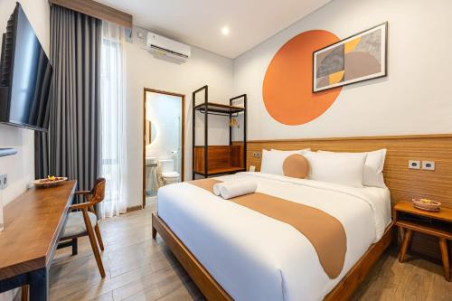 a hotel room with a large bed and a desk at Cove Ruma Coliving in Denpasar