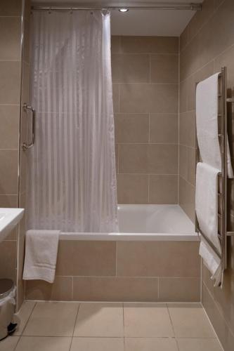 a bathroom with a bath tub and a shower at Broom House at Egton Bridge in Egton