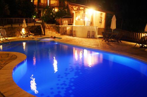 a large blue swimming pool at night at Hotel Praia do Portinho in Ilhabela