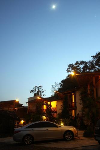 a car parked in front of a house at night at Hotel Praia do Portinho in Ilhabela