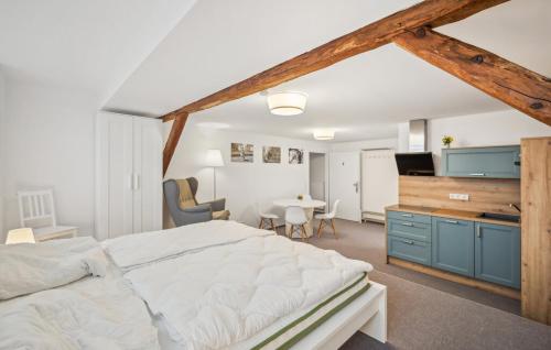 a bedroom with a large white bed and a kitchen at Gut Barzig in Großräschen