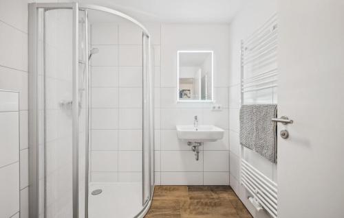 a white bathroom with a shower and a sink at Gut Barzig in Großräschen