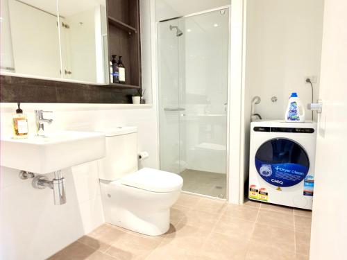 a bathroom with a toilet sink and a washing machine at Chatswood Exeutive Condo - 2 Bedrooms 2 Bathrooms with King Bed in Sydney