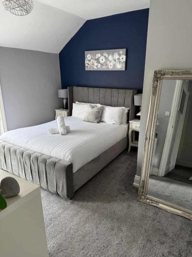 a bedroom with a large bed and a mirror at Your Home from Home - River bank in Cox Green