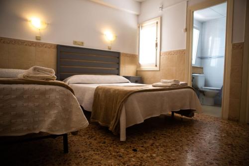 a bedroom with two beds with towels on them at Pensión Juan Pedro in Roquetas de Mar