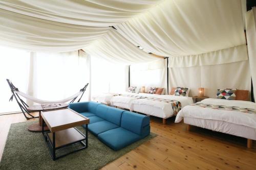 a bedroom with three beds and a blue couch at halfGlamping星音 B in Nakijin