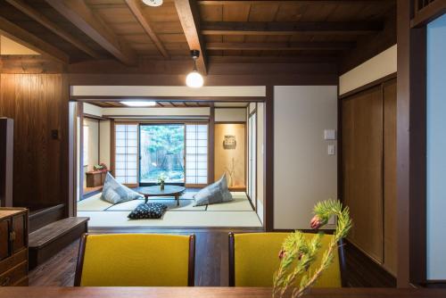 a living room with yellow chairs and a table at Higashiyama Kageroi in Kanazawa