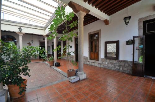 a conservatory with a brick courtyard with potted plants at Howard Johnson by Wyndham Morelia Calle Real in Morelia