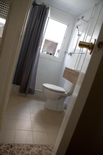 a bathroom with a toilet and a window at Pensión Juan Pedro in Roquetas de Mar
