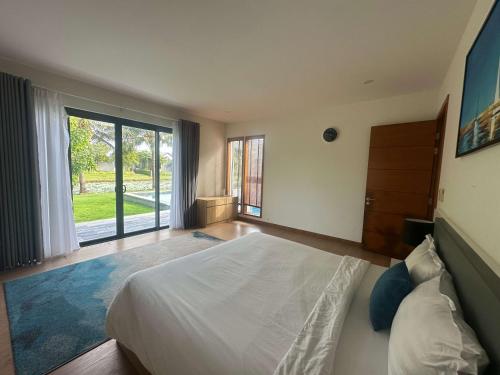 a bedroom with a large bed and a large window at Villa Coastar 002 Hồ Tràm in Ho Tram